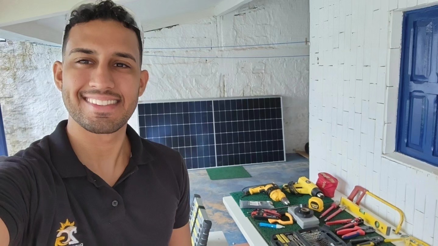 Técnico da 2G Engenharia com ferramentas e módulo solar